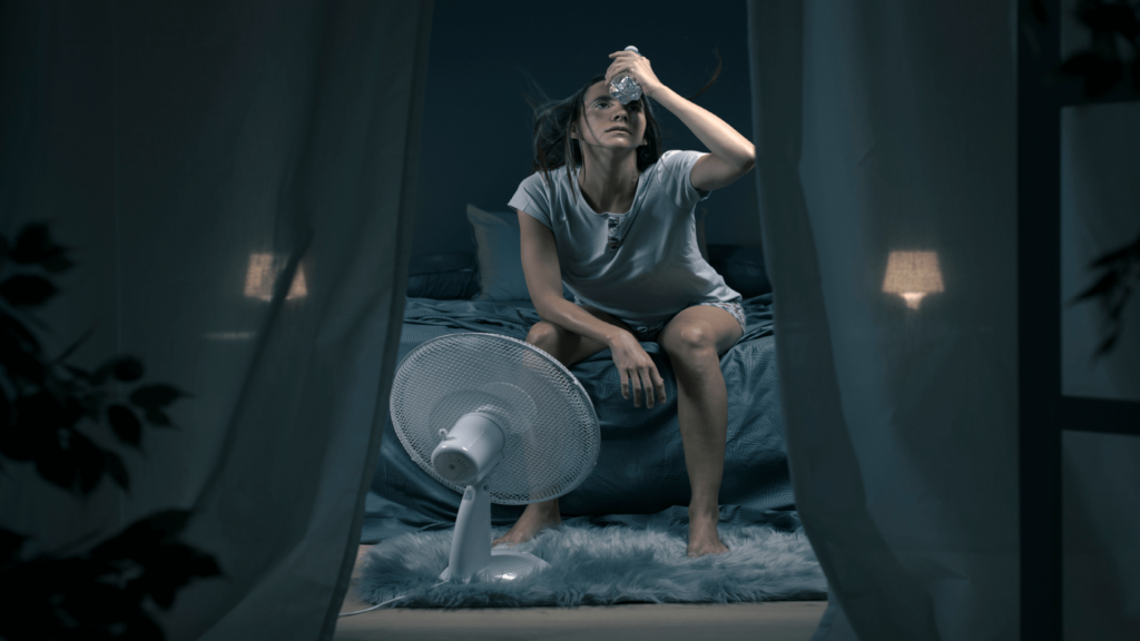 Menopausal woman sitting in front of fan for hot flashes